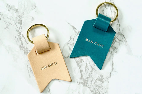 Couple keychain from Bookshell Bindery, in natural pale pink leather, She-shed, and turquoise blue leather, Man-cave