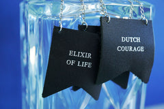 Three custom decanter tags embossed with the phrases Elixir of life and Dutch courage