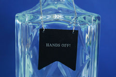 Custom decanter tags from Bookshell Bindery embossed in silver foil with the phrase Hands off!