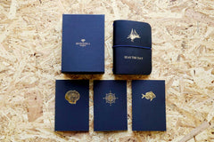 Never-ending journal - Seas the day, leather travel journal, A6 pocket size with boat illustration embossed in gold foil onto the cover, this photo shows all 3 inner notebooks with a shell, fish and compass illustration on the covers
