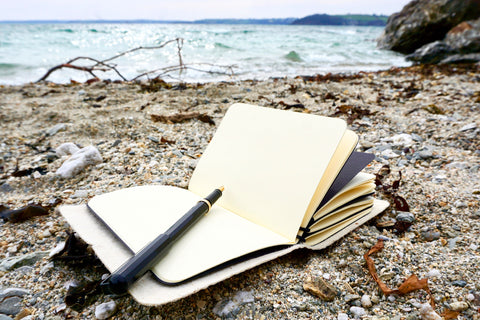 Black Vegan Leather Journal made from Pinatex Pineapple leather from Bookshell Bindery shown here in the beach