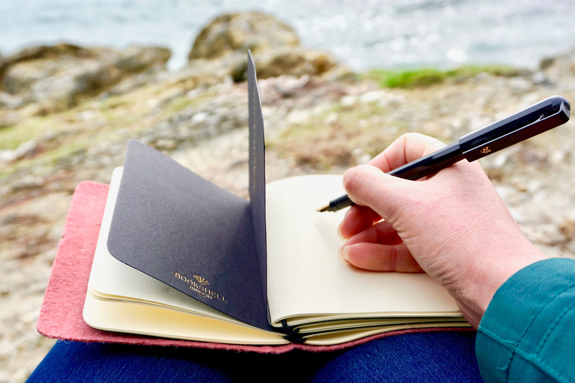 Pink Vegan Leather Journal made from Pinatex Pineapple leather from Bookshell Bindery photographed in use on the beach